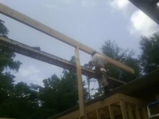Carpenter setting a ridge beam over a new addition frame — Ice Dam Removal by Roofing Brothers in Blackfoot