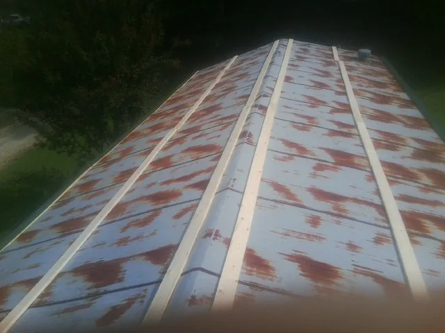 Rusted metal roof panels with new wood purlins before replacement — Storm Damage Roof Repair in Blackfoot by Roofing Brothers