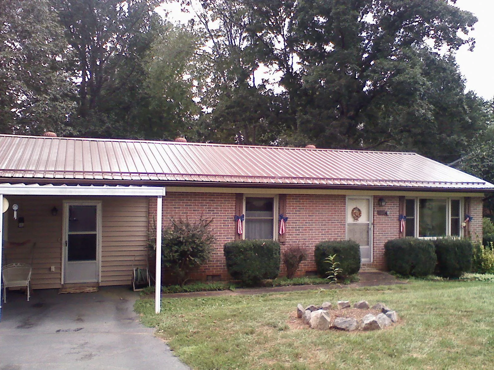 Bronze metal roof and carport on a brick ranch home — Roof Repair work by our crew in Blackfoot